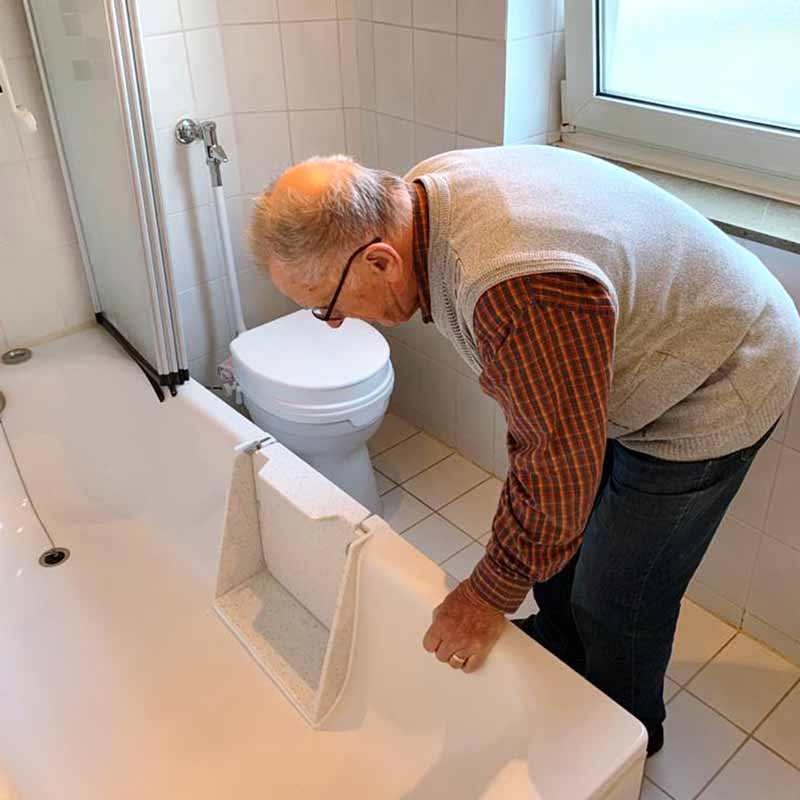 Ein Mann begutachtet seine eingebaute Badewannentüre